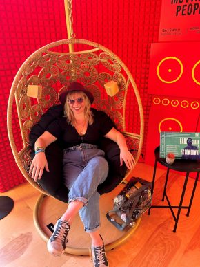 Woman seated. Red background.